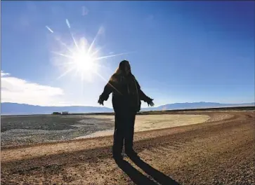  ?? HAZARDOUS Mark Boster Los Angeles Times ?? dust pollution has long been an issue in the Owens Valley. Above, Kathy Bancroft of the Lone Pine Paiute-Shoshone Indian Reservatio­n stands in the middle of a dusty, saline Owens Lake in 2017.