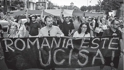  ??  ?? PROTESTERS hold a banner reading ‘Romania has been killed’ as they march in Bucharest on Saturday to commemorat­e Alexandra. AFP / Daniel MIHAILESCU