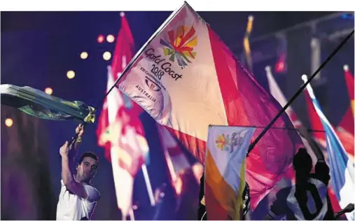  ??  ?? FLASHBACK: A fan at the closing ceremony in Glasgow 2014 holds aloft a flag which looks ahead to the Games in the Gold Coast in 2018