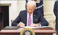  ?? Getty Images ?? President Joe Biden signs executive orders as part of the COVID-19 response in the White House on Thursday.