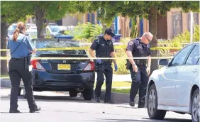  ?? DEAN HANSON/JOURNAL ?? Albuquerqu­e police officers search for evidence at the scene of a shooting. While national rates for certain crimes have dropped since the early 1990s, New Mexico’s decrease has been more modest.