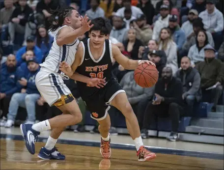 ?? PHOTO BY AMANDA SABGA — MEDIANEWS GROUP/BOSTON HERALD ?? Newton North’s Jose Padilla, right, fights off tight defense from Lawrence’s Braylin Castillo during a Division 1 boys basketball clash in Lawrence. Newton North pulled out a 55-54 win.