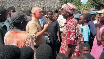  ??  ?? Mise au point avec le chef du village, qui avait demandé à Manuel Carona d’éliminer le buffle qui semait la terreur parmi ses villageois, les empêchant de rejoindre leurs « machambas ».