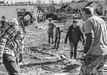  ?? Johnny Milano / New York Times ?? Volunteers help with cleanup Monday in Mayfield, Ky., after a tornado that has left nearly all of the city of about 10,000 without electricit­y. A cluster of twisters hit Kentucky and four other states Friday.