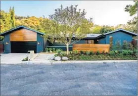  ??  ?? A WOODEN wall helps conceal the 5-foot-wide front door, behind which is a reimagined space of nearly 4,000 square feet.