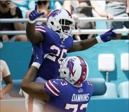  ?? WILFREDO LEE - THE ASSOCIATED PRESS ?? Buffalo Bills running back Devin Singletary (26) is lifted by Buffalo Bills offensive tackle Dion Dawkins (73) after scoring a touchdown during the first half of an NFL football game, Sunday, Sept. 19, 2021, in Miami Gardens, Fla.