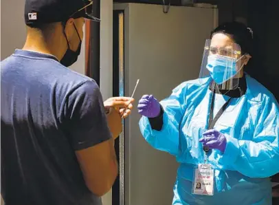  ?? NANCEE E. LEWIS ?? SDSU community health worker Sarah Shamasha takes a specimen (from an individual who did not want to be identified by name) last week for rapid COVID-19 test processing at a pop-up testing site at Encanto Southern Baptist Church.