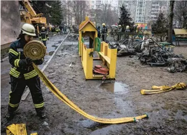  ?? ED RAM/GETTY ?? A firefighte­r rolls up a hose at the site of a deadly helicopter crash Wednesday in Brovary, Ukraine, a Kyiv suburb.