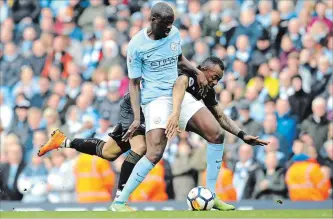  ?? RUI VIEIRA
THE ASSOCIATED PRESS ?? Manchester City’s Yaya Toure, left, and Swansea’s Jordan Ayew battle for the ball during an English Premier League soccer match at Etihad Stadium in Manchester, England, on Sunday. Man City won the game, 5-0.