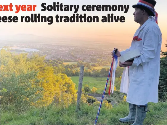  ??  ?? With no runners and no crowds, this year’s cheese roll was purely a symbolic affair, with the Master of Cheese Jem Wakeman, rolling the cheese down an empty hill shortly after sunrise on Monday