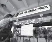  ?? FRIZAL/JAWA POS ?? MASIH TUTUP: Seorang pengunjung melihat pengumuman di papan informasi mal pelayanan publik Siola kemarin (31/8). Rencananya, penutupan instansi pelayanan publik itu berakhir pada 6 September.