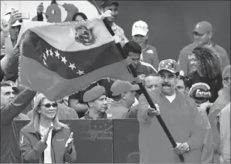  ?? YURI CORTEZ / AFP ?? Venezuelan President Nicolas Maduro waves a national flag during a gathering to mark the 20th anniversar­y of the rise to power of the late Hugo Chavez, in Caracas on Saturday.