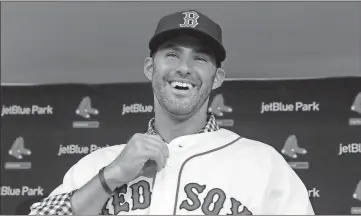  ?? John Minchillo / AP ?? J.D. Martinez smiles to the press in Ft. Myers, Fla., as he buttons up his new Red Sox jersey.