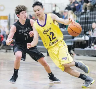  ?? DARREN STONE, TIMES COLONIST ?? Mount Doug Rams guard Matthew Geng tries to drive past Belmont Bulldogs guard Maxwell Leeder during Lower Island senior boys’ action at Mount Doug on Tuesday.