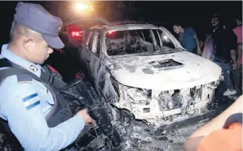  ??  ?? ESCENA. La camioneta blanca fue quemada la tarde del domingo en la zona de La Sabana en San Manuel. Ayer familiares de los ocupantes llegaron ayer a la morgue.