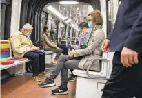  ?? MICHEL EULER AP ?? People wear face masks as they ride a subway in Paris on Thursday. Virus cases are rising fast in France and other countries.