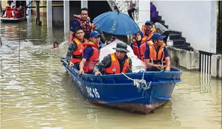  ?? Kelantan. — Bernama ?? By C. A. ZULKIFLE and SYED AZHAR Giving a helping hand: Rescue personnel transporti­ng a sick elderly woman to the hospital at Rantau Panjang,