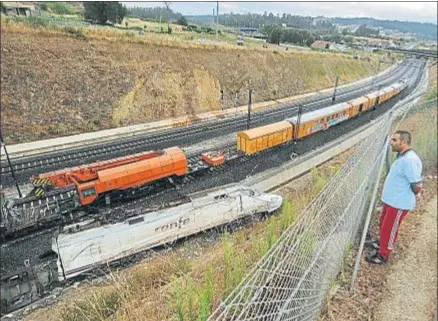  ?? RAFA RIVAS / AFP ?? Un tren pasa junto a la locomotora del Alvia accidentad­o en Angrois en julio del 2013