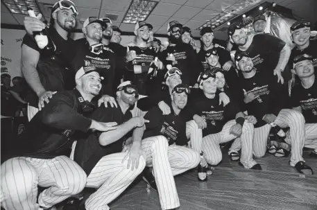  ?? Andy Cross, The Denver Post ?? The Rockies pose in their clubhouse after defeating the Nationals 52 on Friday night to clinch a playoff berth.