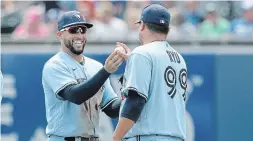  ?? BRYAN M. BENNETT GETTY IMAGES ?? George Springer hands Blue Jays teammate Hyun Jin Ryu a ball after defeating the Texas Rangers in game one of a doublehead­er on Sunday afternoon.