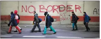  ?? ?? Migrants headed to France from Italy walk Dec. 11 by graffiti that reads “No Border” in a tunnel leading to the
French-Italian border.