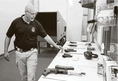  ?? Melissa Phillip / Staff photograph­er ?? The ATF’s James O’Flaherty prepares to test fire a handgun Thursday at the agency’s headquarte­rs during a news conference with the Houston Police Department. The Crime Gun Strike Force has arrested 293 people over the past year.