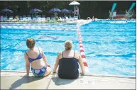  ?? Michael Cummo / Hearst Connecticu­t Media ?? A pair of women sit at the edge of the pool at Newfield Swim &amp; Tennis Club in Stamford.