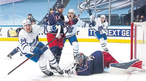  ?? MARK BLINCH GETTY IMAGES ?? After Leafs captain John Tavares and William Nylander, centre, scored late in regulation, Auston Matthews beat Jackets goalie Elvis Merzlikins in overtime on Friday.