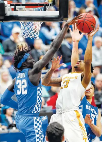  ?? THE ASSOCIATED PRESS ?? Kentucky’s Wenyen Gabriel, left, blocks a shot by Tennessee guard Jordan Bowden during Sunday’s SEC tournament championsh­ip game in St. Louis. Kentucky beat Tennessee 77-72 to win its fourth consecutiv­e league tournament title.