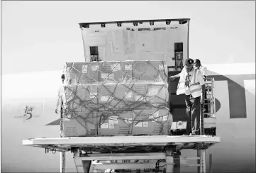  ??  ?? Technician­s unload doses of vaccines from a plane after it landed in Sanaa. — AFP photo