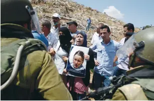  ?? (Mohamad Torokman/Reuters) ?? A PALESTINIA­N PROTESTER holds a picture of Rachel Corrie during a protest in Nabi Saleh in 2012.