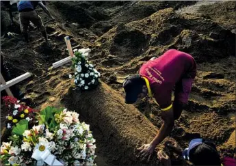  ?? Gemunu Amarasingh­e Associated Press ?? BURIAL WORKERS shape the mound covering a body during a mass interment in Negombo for victims of the Easter bombings. The death toll was raised to 359, and authoritie­s said there were nine bombers.