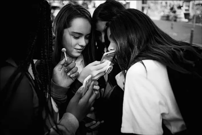  ?? PHOTOS BY DMITRY KOSTYUKOV / THE NEW YORK TIMES ?? From left: Grace Blahourou, Zoélinh Masson, Imane Belaroussi and Lina Zegadi use their phones after school in Paris. France’s education ministry hopes its smartphone ban, which took effect at the beginning of September and applies to primary and middle schools, will get schoolchil­dren to pay more attention in class and interact more.