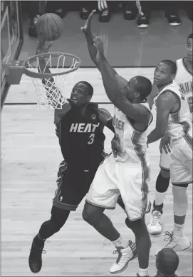  ?? Mike Ehrmann, Getty Images ?? Miami’s Dwyane Wade goes for a layup against Serge Ibaka of Oklahoma City in Game 2 of the NBA Finals on Thursday. The Heat won 100-96 to even the series at 1-1.