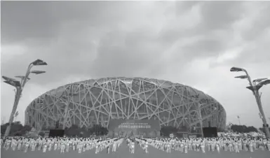  ?? MARK SCHIEFELBE­IN/THE ASSOCIATED PRESS ?? Storm clouds gather over Beijing’s Olympic Stadium, also known as the Birds Nest, the epicentre of the city’s 2008 Olympics.