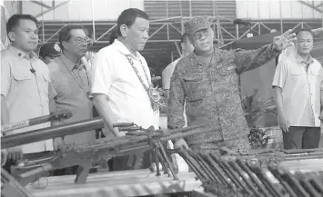  ?? PRESIDENTI­AL PHOTO ?? President Rodrigo Roa Duterte leads the inspection of the firearms recovered from the New People's Army, which were presented during the recent 12th anniversar­y of the Eastern Mindanao Command (EastMinCom) at the Naval Forces Eastern Mindanao (NFEM), Naval Station Felix Apolinario (NSFA) in Panacan, Davao City.