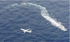  ?? — Reuters ?? A Japan Coast Guard patrol vessel and US Navy airplane conduct search and rescue operation at the area where two US Marine Corps aircraft have been involved in a mishap in the skies.