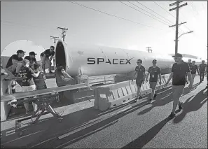  ?? AP/DAMIAN DOVARGANES ?? Members of the WARR team from Technische Universita­t Munchen walk to the end of the SpaceX’s Hyperloop track to retrieve their winning pod in Hawthorne, Calif., last month.