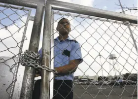  ?? Juan Carlos Hernandez / Associated Press 2009 ?? A security guard in 2009 stands behind a fence at the General Motors assembly plant in Valencia, which was seized by Venezuelan authoritie­s Wednesday.