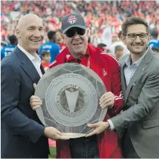  ?? FRANK GUNN/THE CANADIAN PRESS ?? Maple Leafs Sports and Entertainm­ent chairman Larry Tanenbaum, centre, got his hands on the Supporters’ Shield this season, but his team is still chasing a bigger prize, the MLS Cup.