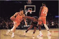  ?? Elsa / Getty Images ?? The Suns’ Devin Booker, left, during Friday’s game against the Knicks.