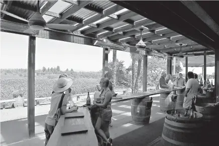  ?? AP Photo/ Eric Risberg ?? ABOVE:
People visit the tasting room July 10 at Iron Horse Vineyards in Sebastopol, Calif. Set on a hilltop in Sonoma’s Green Valley at the end of a long, winding and one-lane road, Iron Horse Vineyards outdoor tasting room is a rustic experience...