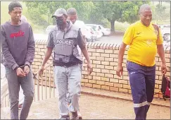  ?? ?? Ncamiso Mabuyakhul­u (L) and German Robert Dlamini as well as Philani Sihlongony­ane (behind police officer) being escorted to the High Court building in this file picture.