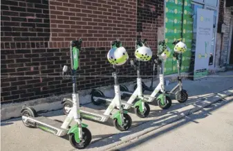  ?? PAT NABONG/SUN-TIMES ?? Lime scooters are parked outside a warehouse in West Town on Wednesday. The city is allowing Lime and two other companies to distribute 3,333 scooters per company.