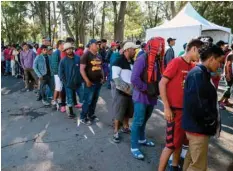  ??  ?? Migrants from Central American countries — mostly Hondurans — heading in a caravan to the US, queue to receive clothes and shoes at a temporary shelter in a sport centre, in Mexico City on Monday. — AFP