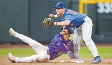  ??  ?? LSU’s Kramer Robertson is caught trying to steal second base by Florida second baseman Deacon Liput on Monday night during the seventh inning of Game 1 of the College World Series finals in Omaha. Nati Harnik, The Associated Press