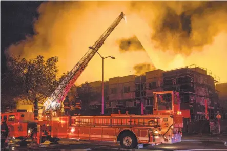  ?? John Orvis ?? Firefighte­rs battle a blaze at a residentia­l constructi­on site in West Oakland. It was the second time the site has caught fire.