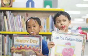  ??  ?? COUSINS Charlie (in blue) and Luther spend their lunch break at the library to read on their favorite books.