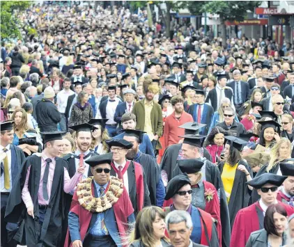  ?? PHOTO: GERARD O’BRIEN ?? On the move . . . University of Otago graduands walk along George St, Dunedin, in a graduation parade before yesterday’s two graduation ceremonies at the Dunedin Town Hall.