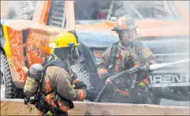  ??  ?? Firefighte­rs extinguish a vehicle fire on I-15 from a collision that killed three people. Authoritie­s suspect speeding and reckless driving caused the crash.